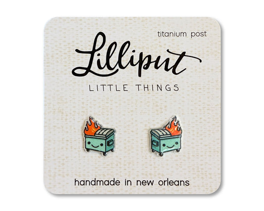 A pair of kawaii-style earrings featuring a cartoonish dumpster on fire, displayed on a card with 'Lilliput Little Things' branding.