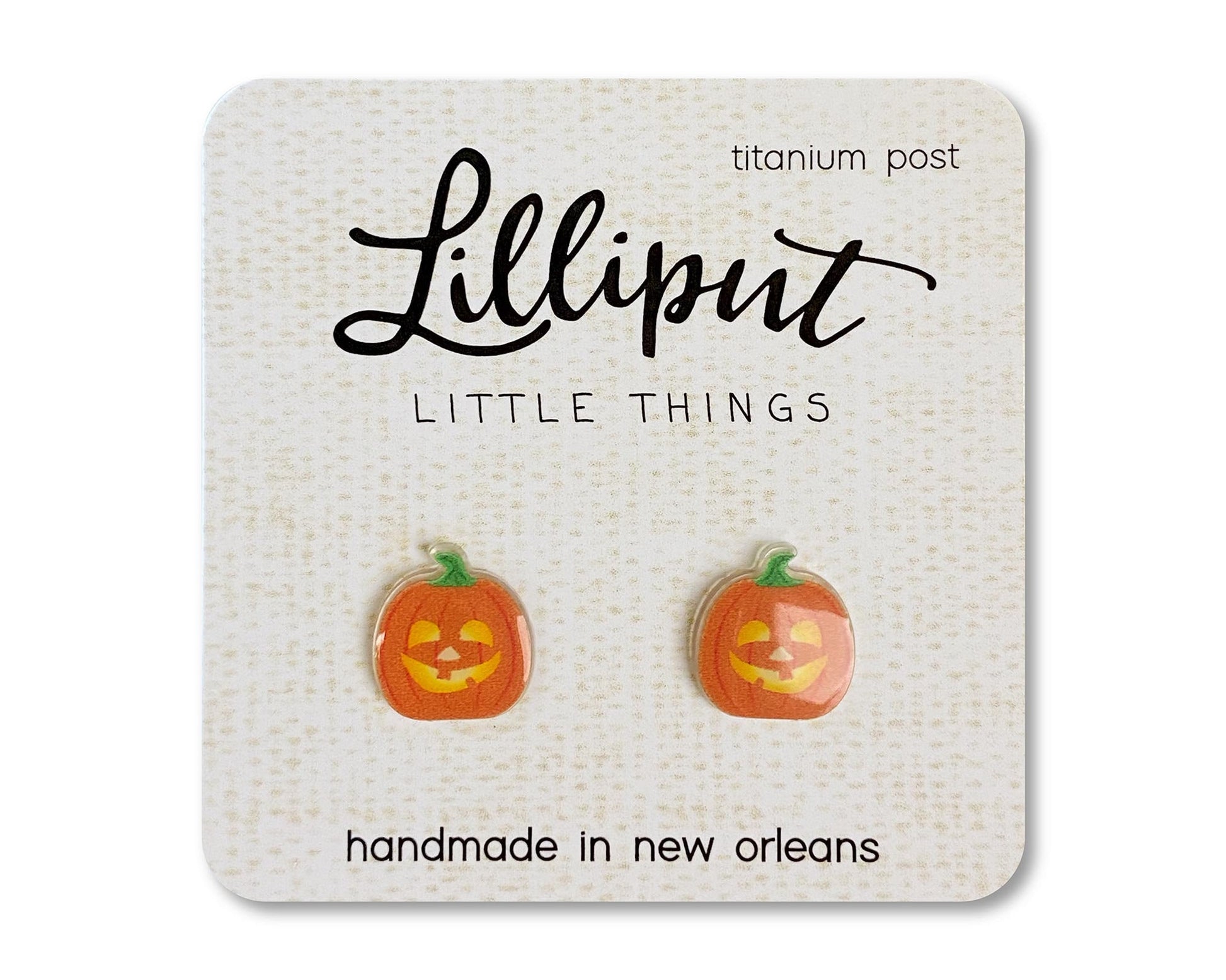 A pair of pumpkin shaped titanium earrings on a card that reads 'Lilliput Little Things, handmade in New Orleans, LA.'