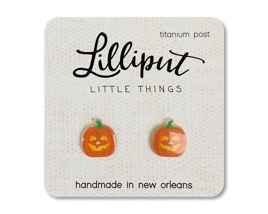 A pair of pumpkin shaped titanium earrings on a card that reads 'Lilliput Little Things, handmade in New Orleans, LA.'