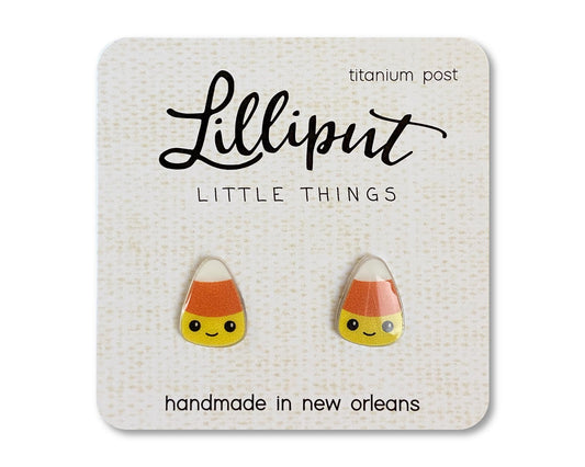 A pair of kawaii candy corn earrings on a card, with the brand name 'Lilliput Little Things' and 'handmade in New Orleans, titanium post' printed on it.